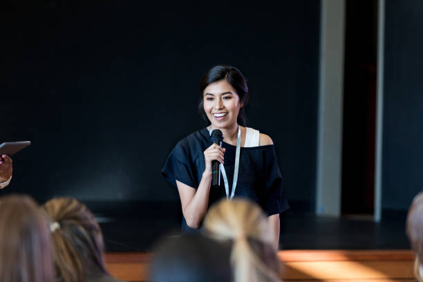 Young Hispanic woman gives a motivating speech during a conference or seminar.